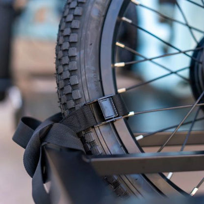 Close-up of a fat tire electric trike wheel secured with a hitch rack strap